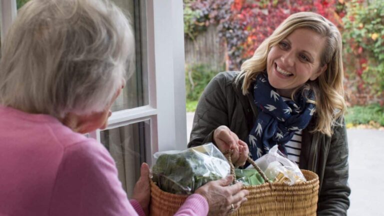 Female Neighbor Helping Senior Woman With Shopping