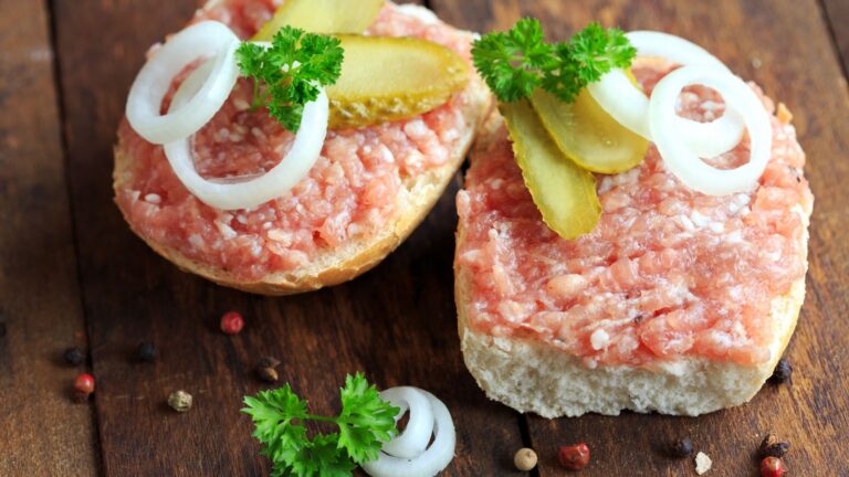 mettbrötchen with onions on wooden table